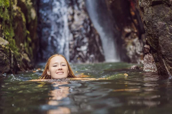 Jonge mooie vrouw in het water bij de waterval — Stockfoto