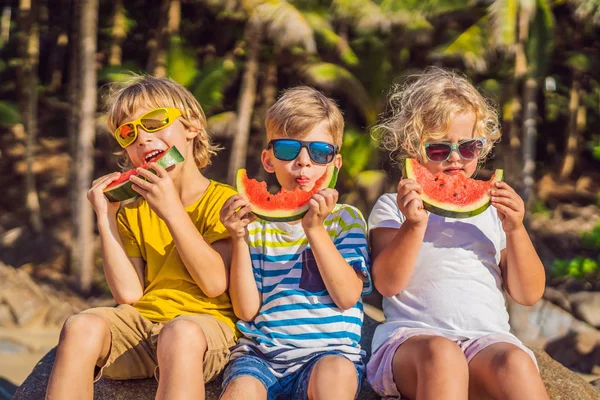 Діти їдять кавун на пляжі в сонцезахисних окулярах — стокове фото