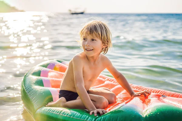 Мальчик плавает в море на надувном матрасе — стоковое фото