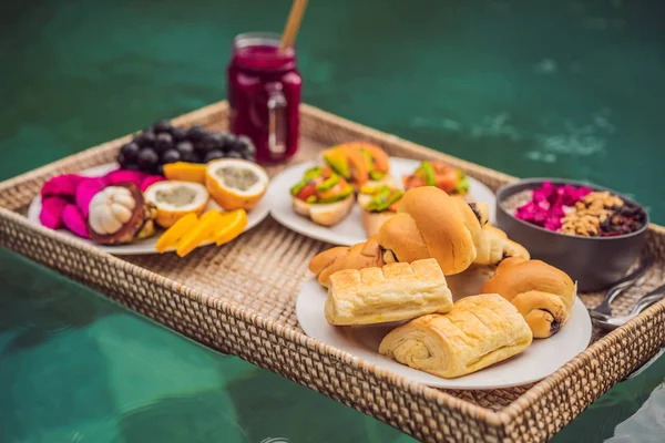 Bandeja de pequeno-almoço na piscina, pequeno-almoço flutuante em smoothies hotel de luxo e prato de frutas, tigela de smoothie junto à piscina do hotel. Dieta de verão exótica. Estilo de vida na praia tropical. Bali Trend — Fotografia de Stock