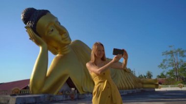 Phuket adasında yatan Buda heykeli ile Wat Srisoonthorn tapınağı ziyaret genç bir kadın gezgin slowmotion çekim. Travell Tayland konsepti