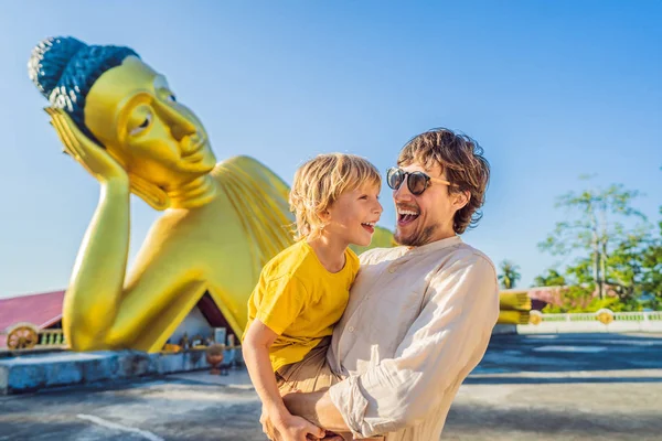 Gelukkige toeristen vader en zoon op achtergrond oflying Boeddha standbeeld — Stockfoto