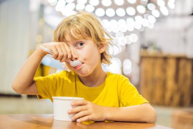 Bir kafede dondurma yiyen çocuk