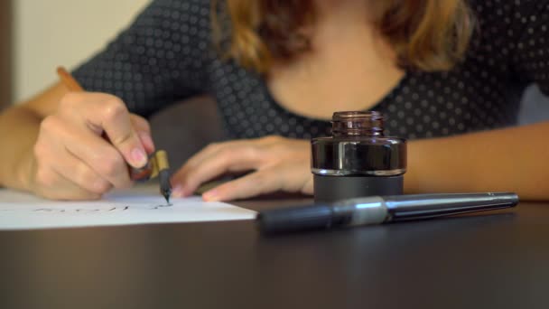 Közelről lövés egy fiatal nő kalligráfia írás a papíron segítségével betűkkel technika — Stock videók