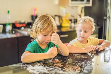İki çocuk bir erkek ve bir kız hamurdan kurabiye yapmak