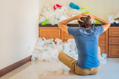 Adam bütün mutfağı doldurmak için çok fazla plastik torba kullanmış. Sıfır atık. Dünya Çevre Günü kavramı