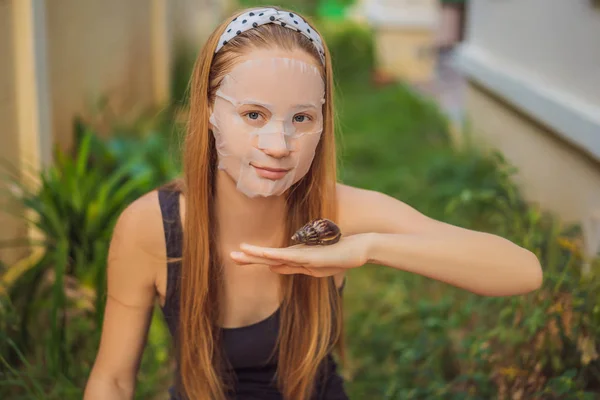 Una giovane donna fa una maschera facciale con muco di lumaca. Lumaca strisciare su una maschera viso — Foto Stock