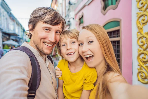 Mom, Dad and Son tourists on the Street in the Portugese style Romani in Phuket Town. Also called Chinatown or the old town. Traveling with kids concept