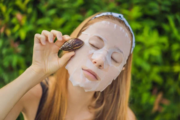 Una mujer joven hace una máscara facial con moco de caracol. Caracol arrastrándose sobre una máscara facial —  Fotos de Stock