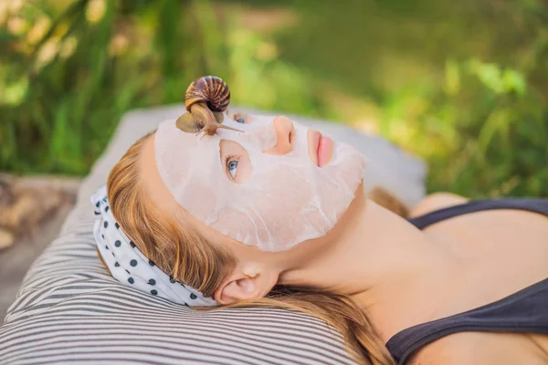 Młoda kobieta robi maskę na twarz ze ślimakiem. Ślimak czołgający się na masce twarzy — Zdjęcie stockowe