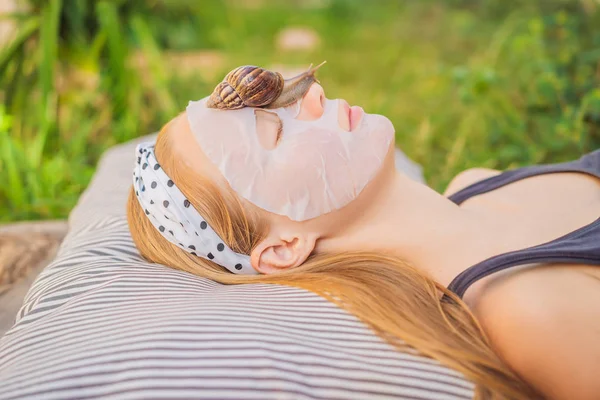 Une jeune femme fait un masque avec du mucus d'escargot. Escargot rampant sur un masque facial — Photo