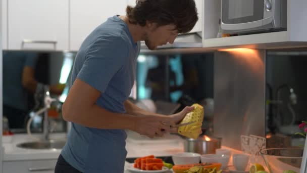 Un joven en una cocina preparando el desayuno con frutas tropicales frescas para su familia — Vídeos de Stock