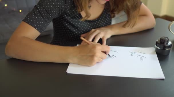 特写镜头,一位年轻女子用书写技巧在纸上书写书法。她写我爱你 — 图库视频影像