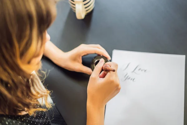 I love you. Calligrapher Young Woman writes phrase on white paper. Inscribing ornamental decorated letters. Calligraphy, graphic design, lettering, handwriting, creation concept — Stock Photo, Image
