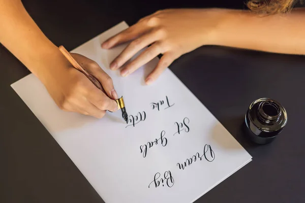 Dream Big set doelen actie te ondernemen. Kalligrafie jonge vrouw schrijft zin op wit papier. Het schrijven van sier versierde letters. Kalligrafie, grafisch ontwerp, belettering, handschrift, creatie concept — Stockfoto