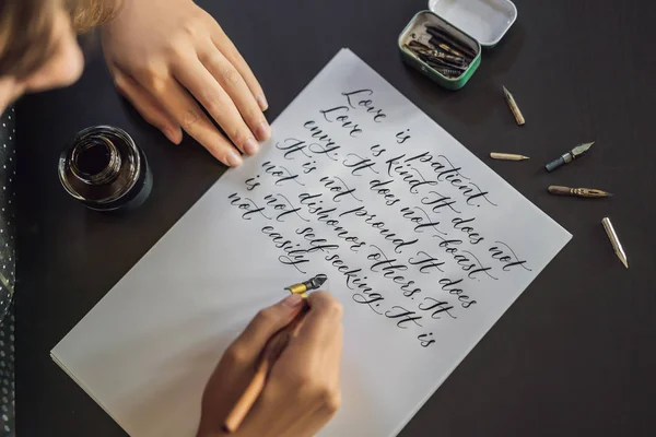 Kaligraf ręce pisze frazę na białym papierze. Zwrot o ozdobnych urządzone miłosne Inscribing. Kaligrafia, projektowanie graficzne, liternictwo, pisma, koncepcja stworzenia — Zdjęcie stockowe
