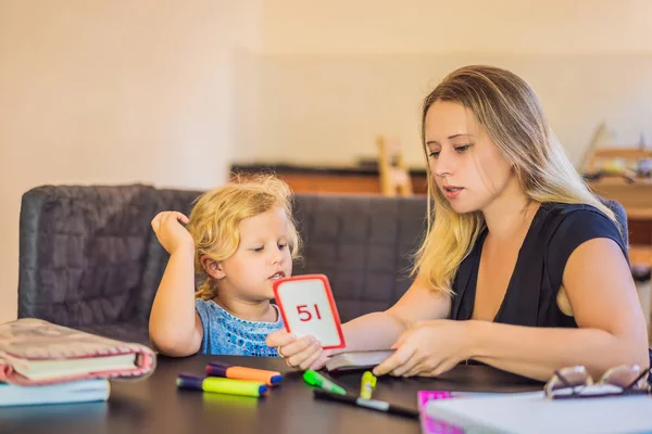 Un insegnante, un tutor per la scuola a casa e un insegnante a tavola. O mamma e figlia. Istruzione a domicilio — Foto Stock