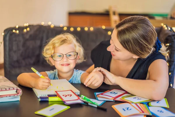 Un profesor, un tutor para la educación en casa y un profesor en la mesa. O mamá y su hija. Educación en el hogar — Foto de Stock