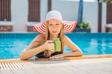 Havuz arka planda ıspanak ve muz yeşil smoothie ile kadın. Sağlıklı yiyecekler, sağlıklı Smoothie 'ler