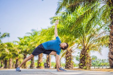Tropik bir parkta yoga yapan adam