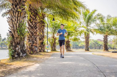 Tropik parkta koşan koşucu atlet. adam fitness gündoğumu koşu egzersiz sağlıklı yaşam kavramı