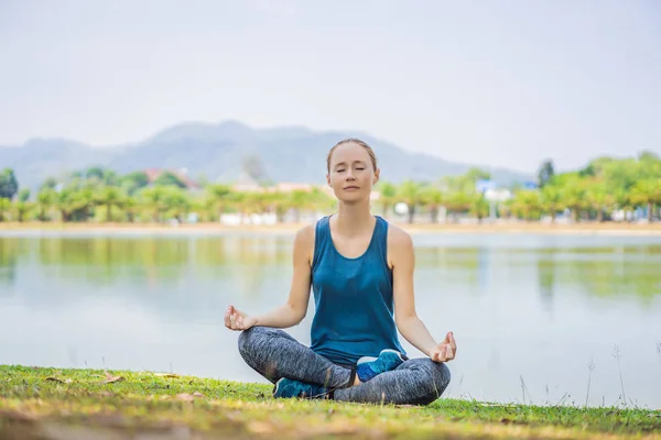 Kvinna som gör yoga i en tropisk park — Stockfoto