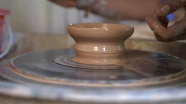 Bir öğretmen çömlekçi nasıl bir Pottertekerlek üzerinde kil kase yapmak için çırak öğretim Slowmotion closeup çekim