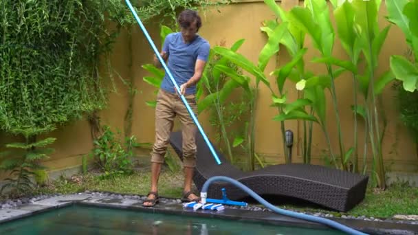 Jovem homem profissional piscina limpador faz serviço de limpeza da piscina — Vídeo de Stock
