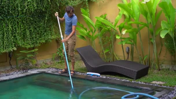 Jovem homem profissional piscina limpador faz serviço de limpeza da piscina — Vídeo de Stock