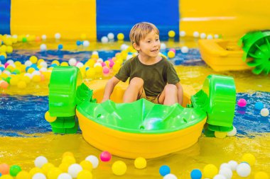 Teknede mutlu genç çocuk eğlence parkında oynarken zevk