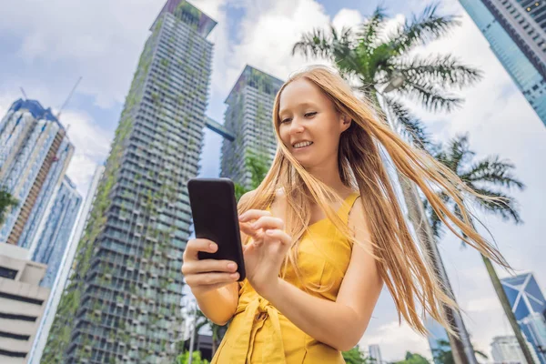 Vrouw toerist met behulp van de navigatie-app op de mobiele telefoon. Navigatiekaart op een smartphone in een grote stad — Stockfoto