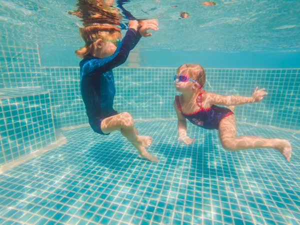 Kinder spielen in den Sommerferien unter Wasser im Schwimmbad — Stockfoto