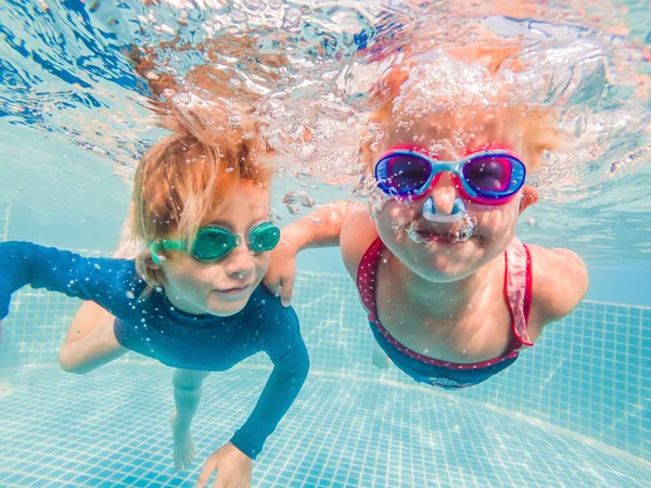 Kinder spielen in den Sommerferien unter Wasser im Schwimmbad — Stockfoto