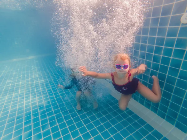 Kinder spielen in den Sommerferien unter Wasser im Schwimmbad — Stockfoto