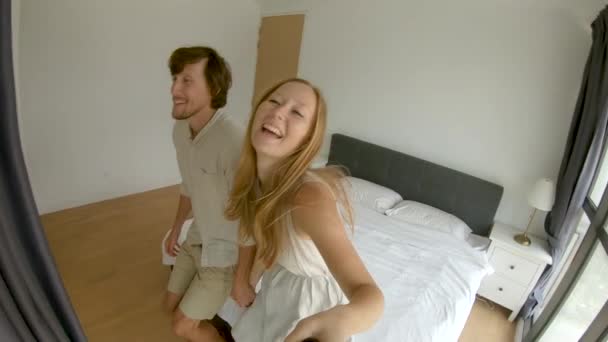 幸せなカップルの男女がベッドに落ちるスローモーションショット。旅行のコンセプト。ハネムーンコンセプト — ストック動画