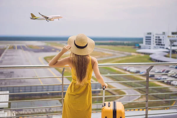 Beginn ihrer Reise. Schöne junge Frau im gelben Kleid und gelbem Koffer wartet auf ihren Flug — Stockfoto