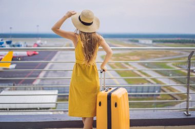 Yolculuğunun başlangıcı. Sarı bir elbise ve sarı bir bavul içinde güzel genç kadın ltraveler onu uçuş bekliyor