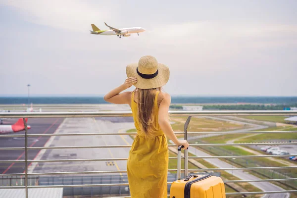 Beginn ihrer Reise. Schöne junge Frau im gelben Kleid und gelbem Koffer wartet auf ihren Flug — Stockfoto