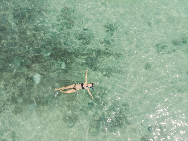 Vue aérienne du dessus de la femme faisant de la plongée avec tuba d'en haut, une jeune fille nageant dans une eau de mer tropicale claire avec des coraux pendant les vacances d'été — Photo