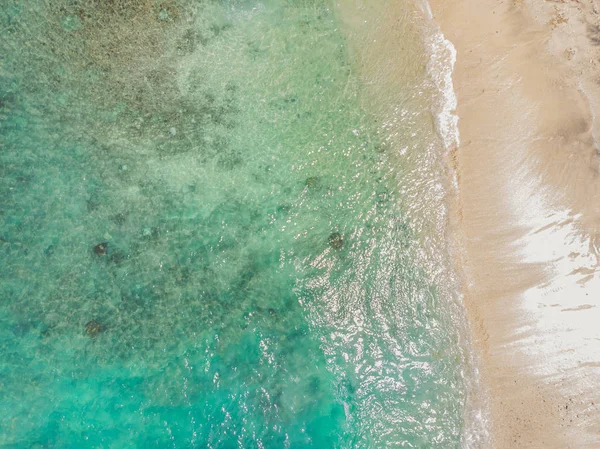 Turkuaz su ve küçük beyaz plaj ile deniz koyu. Güzel lagün ve volkanik ada yoğun orman ile kaplı, yukarıdan görünümü