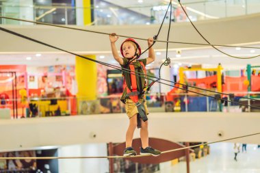 Sevimli küçük çocuk alışveriş merkezinde macera parkı tırmanma onun zaman zevk