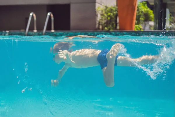 Chlapec se baví hrát pod vodou v bazénu na letních prázdninách — Stock fotografie