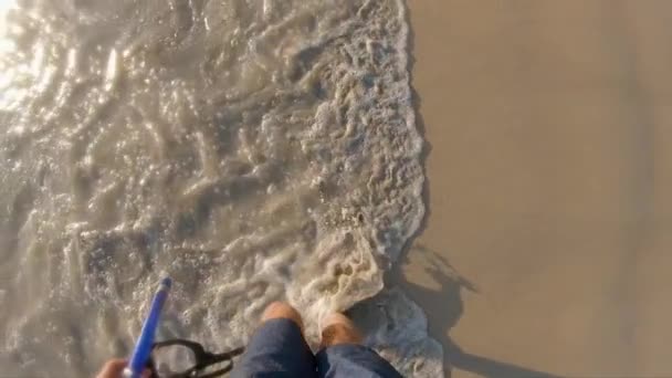 Superslowmotion disparo de un hombre que camina en olas de mar sosteniendo máscara de snorkel en su mano — Vídeo de stock