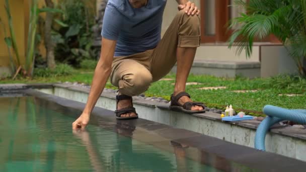 Joven hombre de servicio de la piscina de control de cloro, PH y otros niveles químicos — Vídeo de stock