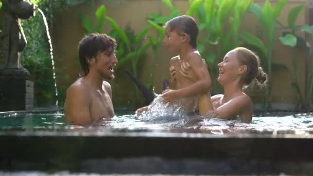 Família feliz - pai mãe e filho se divertem em sua piscina — Vídeo de Stock