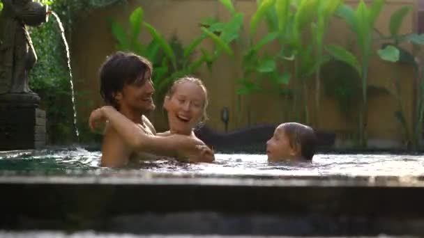 Família feliz - pai mãe e filho se divertem em sua piscina — Vídeo de Stock