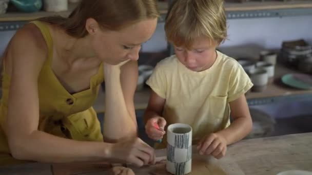 Una joven y su pequeño hijo en una clase magistral de cerámica — Vídeos de Stock