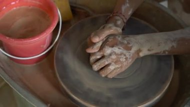Bir öğretmen çömlekçi nasıl bir Pottertekerlek üzerinde kil kase yapmak için çırak öğretim Slowmotion closeup çekim