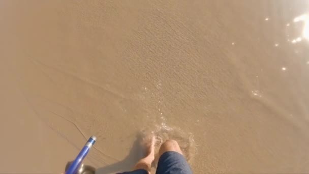 Superslowmotion disparo de un hombre que camina en olas de mar sosteniendo máscara de snorkel en su mano — Vídeos de Stock