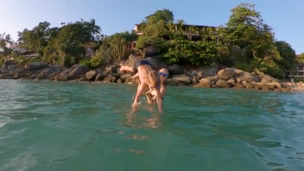 Superzeitlupenaufnahme eines jungen Vaters, der seinen kleinen Sohn ins Meer führt. Sommerkonzept. Reisen mit Kinderkonzept — Stockvideo